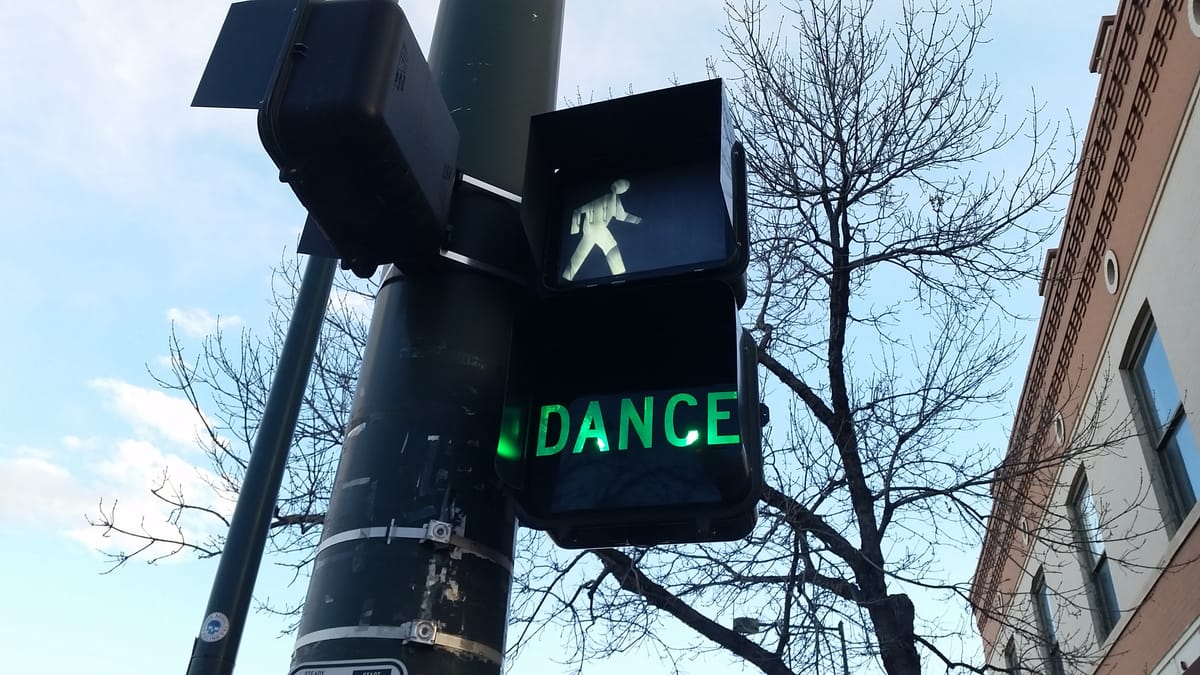 Walk sign and illuminated sign below reading DANCE