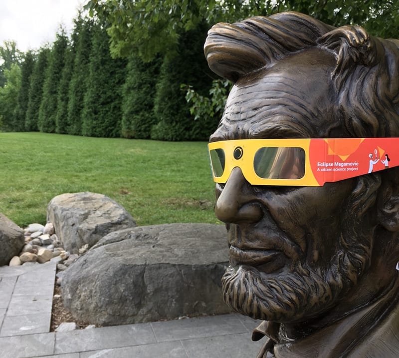 Statue of President Lincoln wearing eclipse glasses. 