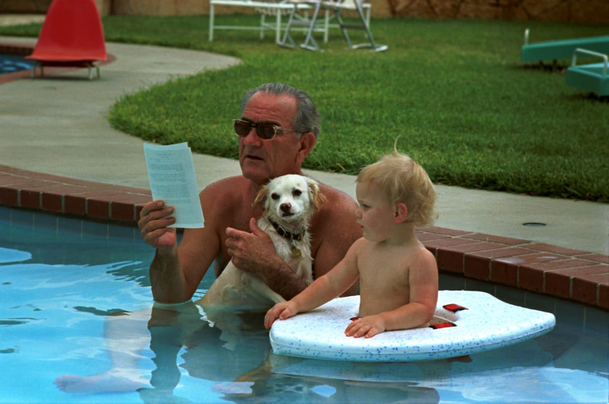 Lyndon Johnson reading a memo in the pool. 