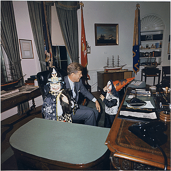 President Kennedy is visited in his office by his kids in Halloween costumes. 