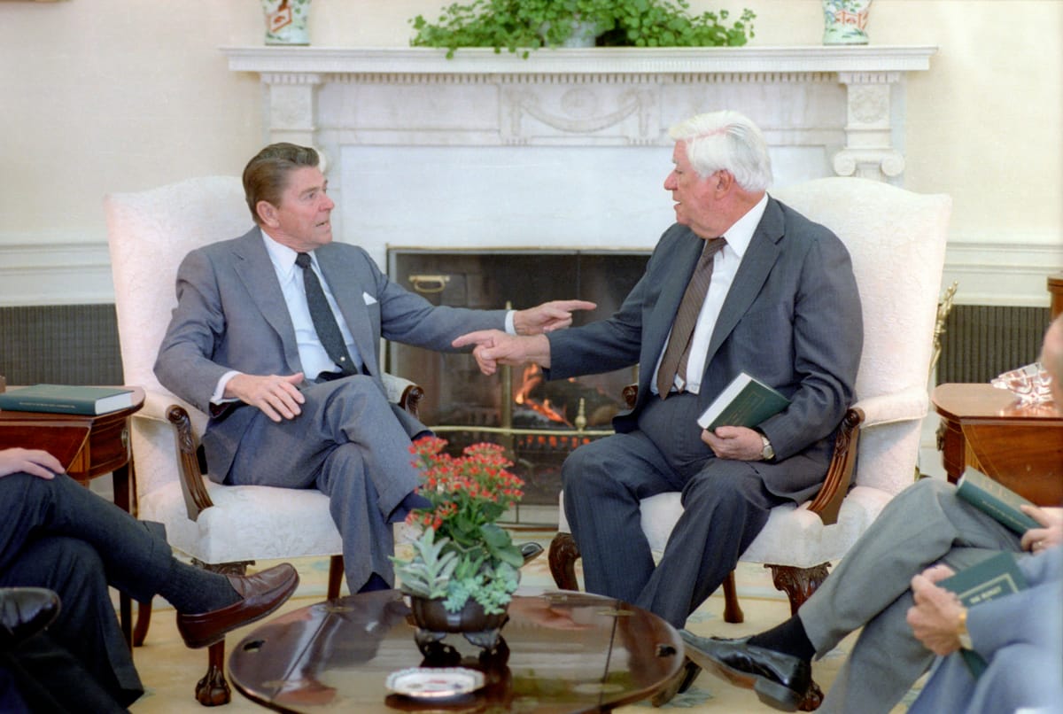 President Reagan and Speaker Tip O'Neill point at each other. 